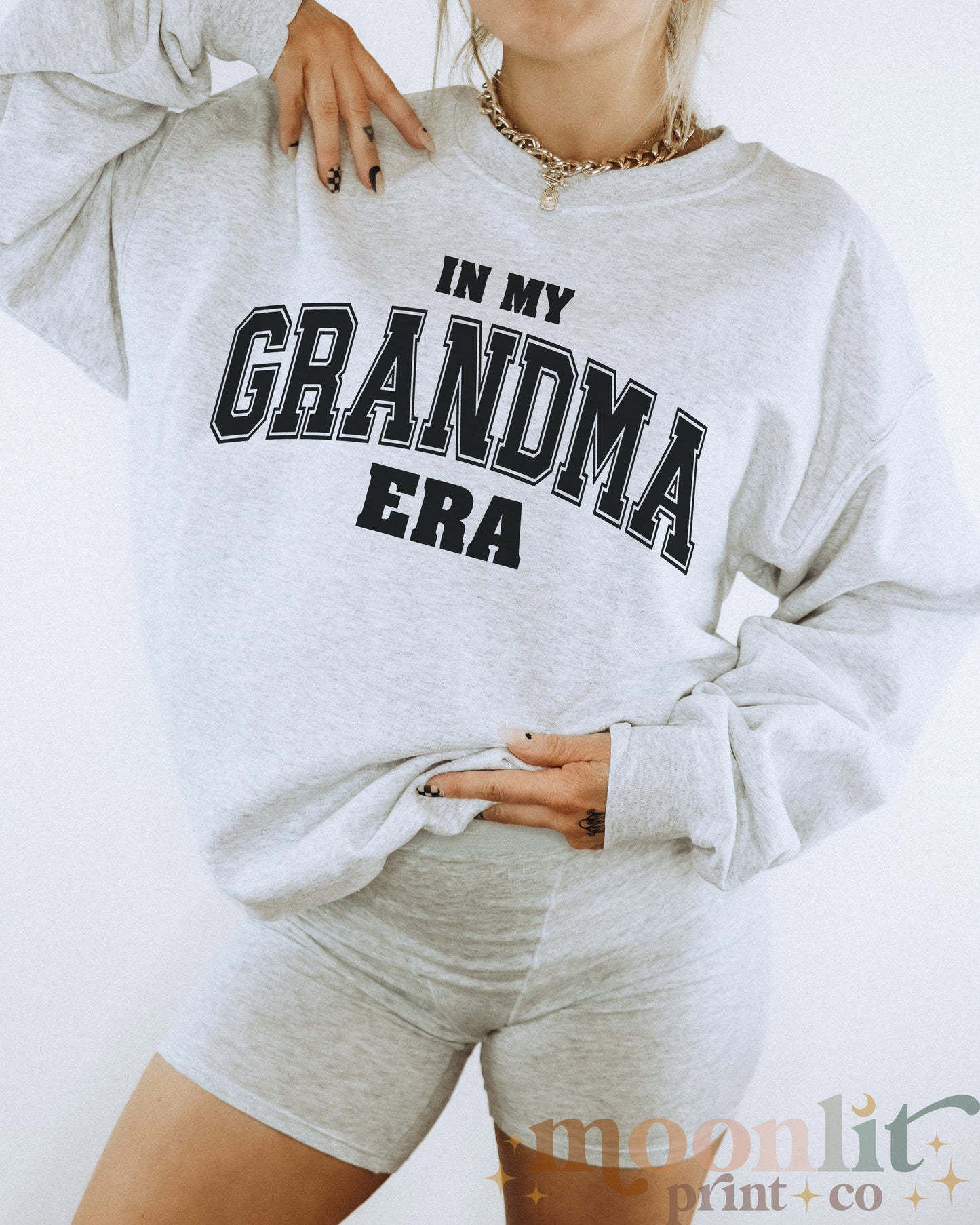 a woman wearing a gray sweatshirt and shorts