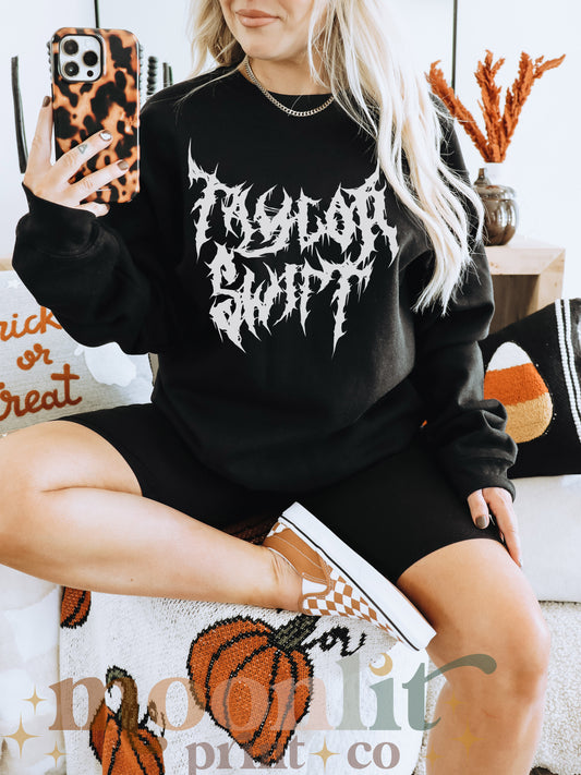 a woman sitting on a couch wearing a black sweatshirt