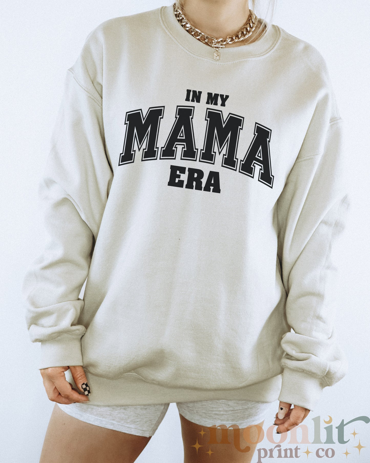 a woman wearing a sweatshirt that says in my mama era