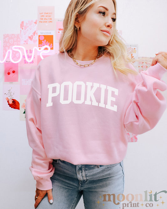 a woman wearing a pink sweatshirt with pookie on it