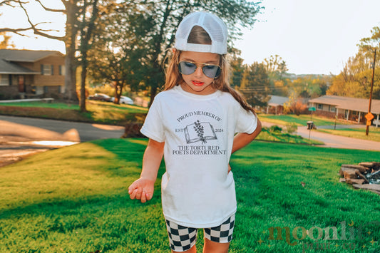 a little girl wearing a white shirt and checkered shorts