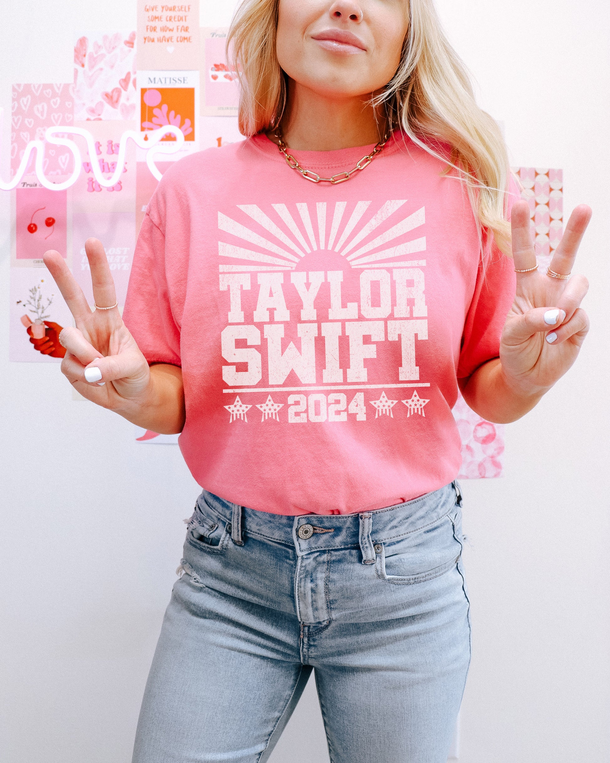 a woman wearing a pink taylor swift shirt