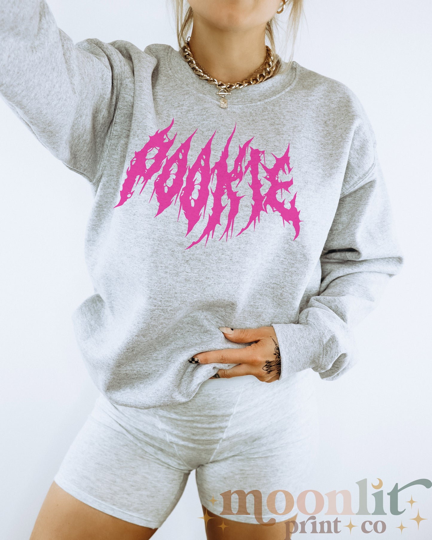 a woman wearing a grey sweatshirt with pink paint on it