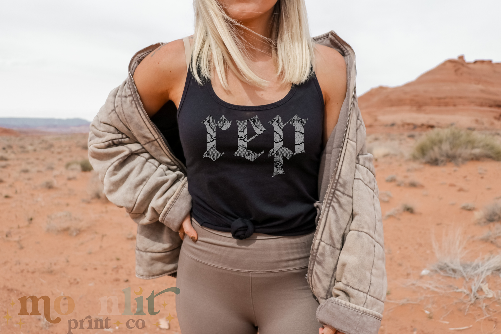 a woman with blonde hair wearing a black shirt and tan pants