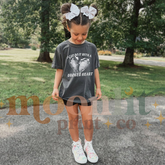 a little girl standing on top of a road