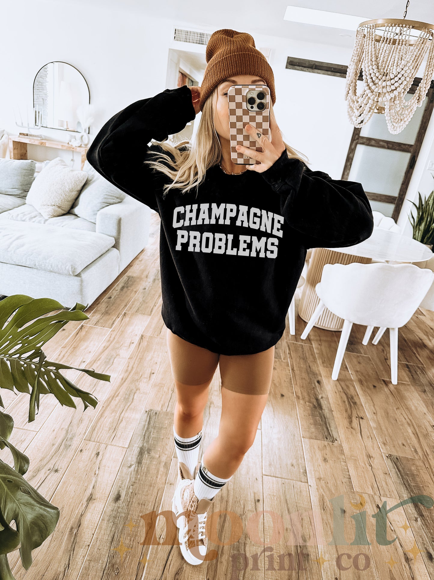 a woman wearing a black sweatshirt with the words champagne problems printed on it