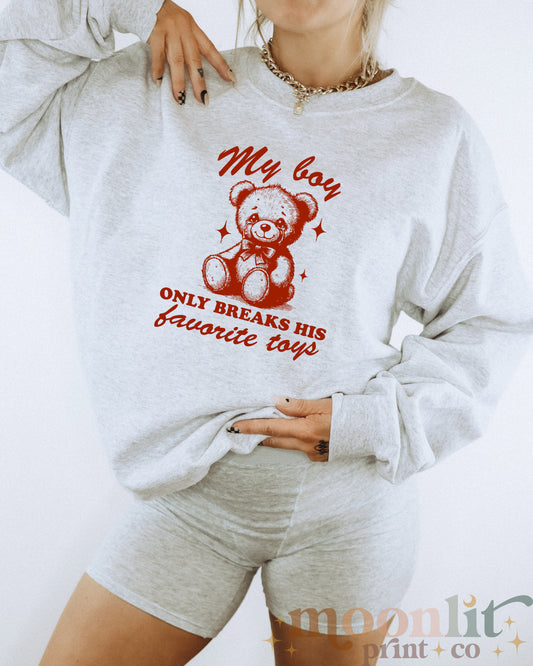 a woman wearing a sweatshirt with a teddy bear on it