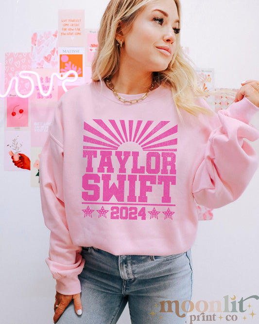 a woman wearing a pink taylor swift sweatshirt