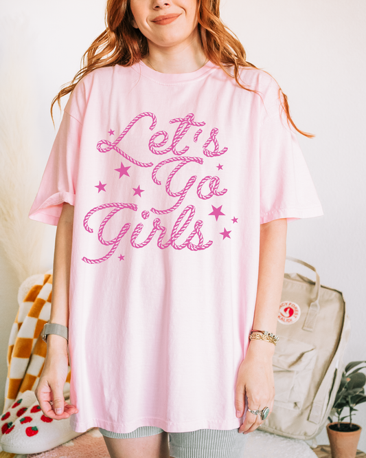 a woman wearing a pink shirt that says let's go girls