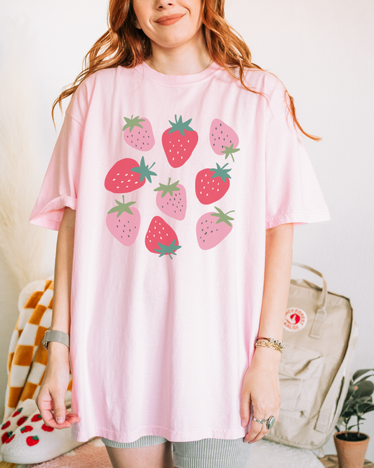 a woman wearing a pink shirt with strawberries on it